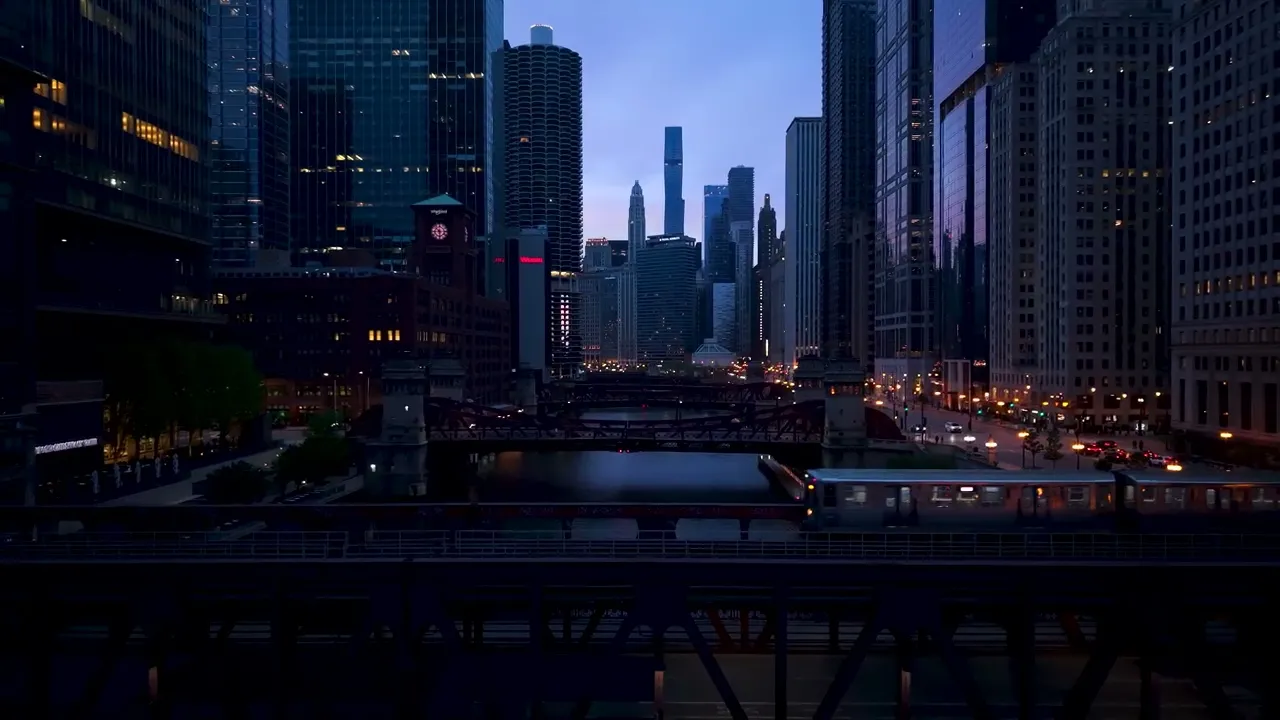 Aerial drone view of the Chicago skyline at dusk with an elevated train crossing the river